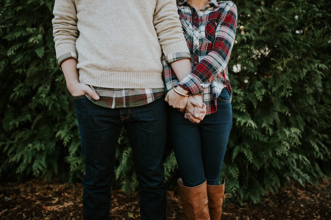 Par som støtter hverandre og viser forståelse ved å holde hender og stå tett sammen