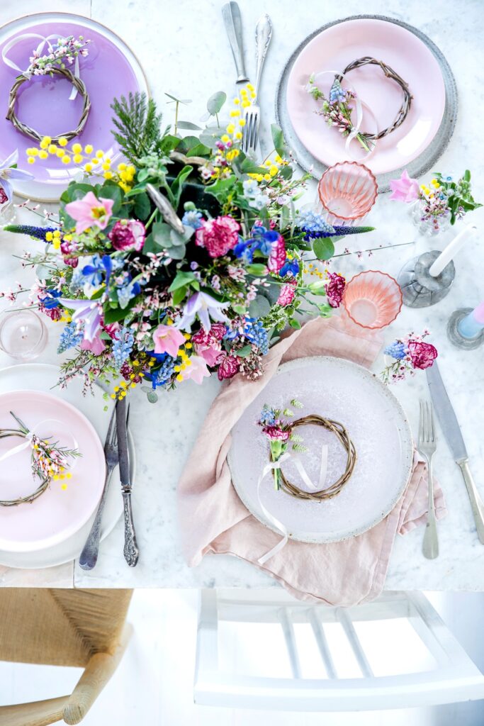 borddekorasjon bryllup med tallerkener, blomster og spreke farger
